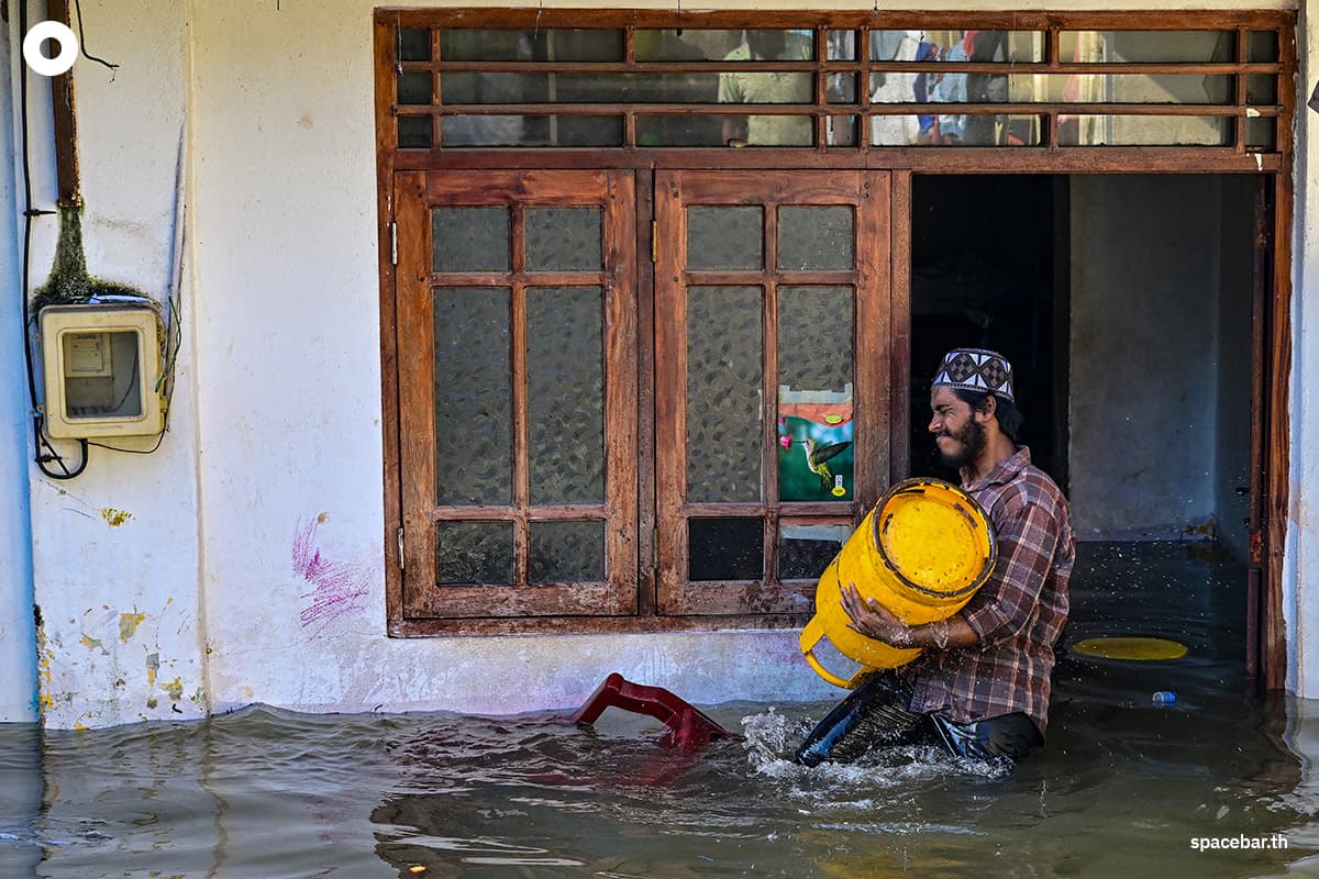 ชายคนหนึ่งกำลังแบกถังแก๊สอยู่หน้าบ้านที่ถูกน้ำท่วมในเมืองเวลลัมปิติยา ชานเมืองโคลัมโบ เมื่อวันที่ 30 พฤศจิกายน 2025 Photo by ISHARA S. KODIKARA / AFP