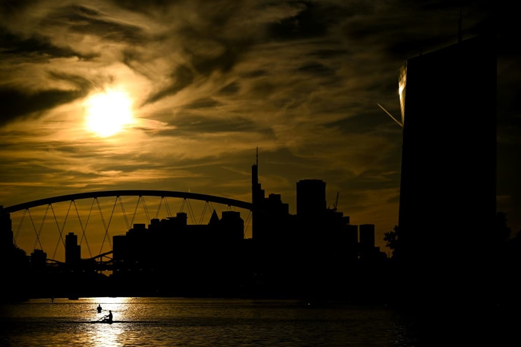 ผู้คนกำลังพายเรือในแม่น้ำบริเวณด้านหน้าสำนักงานใหญ่ของธนาคารกลางยุโรปและย่านธุรกิจธนาคารในเมืองแฟรงก์เฟิร์ต