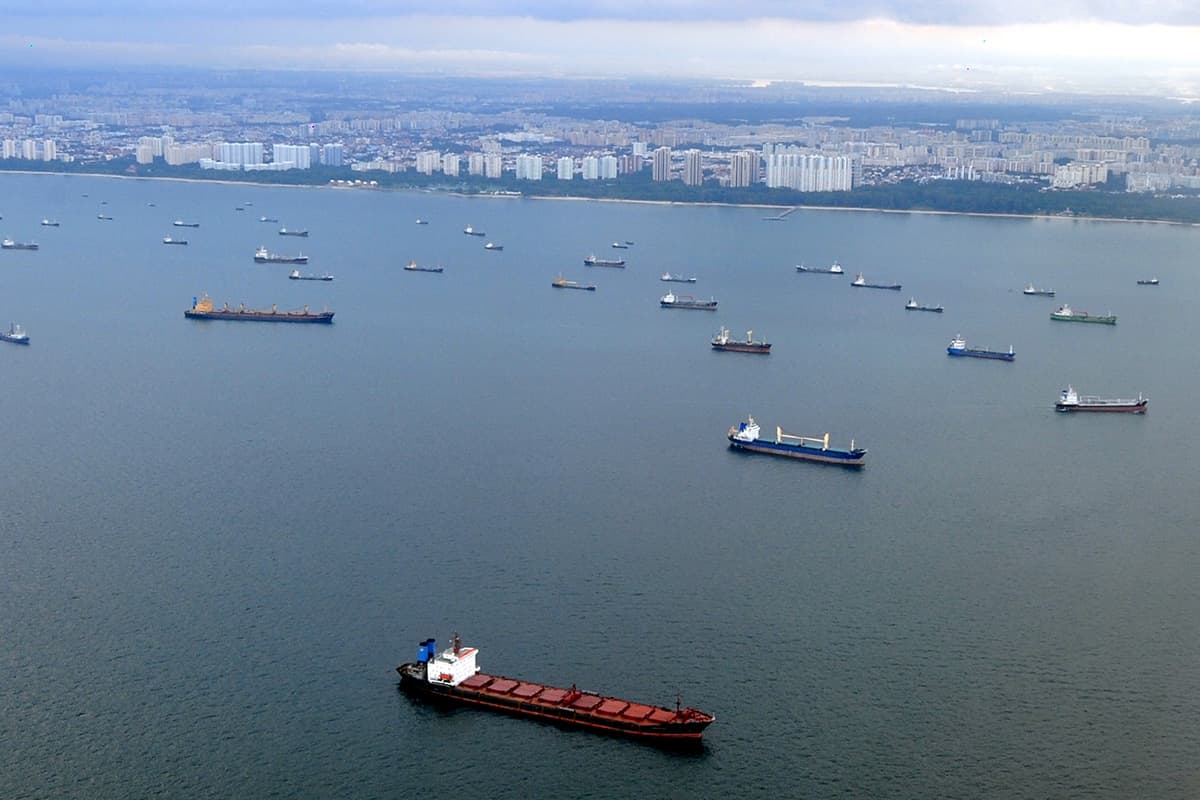 ภาพถ่ายทางอากาศเมื่อวันที่ 23 มีนาคม 2008 แสดงให้เห็นเรือลำหนึ่ง (ด้านล่าง) แล่นผ่านเรือที่จอดทอดสมออยู่ตามแนวชายฝั่งของสิงคโปร์บริเวณปากช่องแคบมะละกา Photo by ROSLAN RAHMAN / AFP FILES / AFP