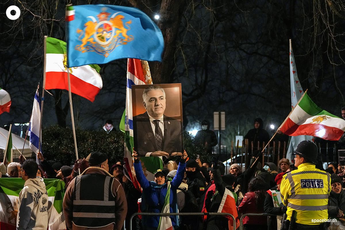 ผู้ประท้วงต่อต้านระบอบอิหร่านชูภาพเหมือนของ โมฮัมหมัด เรซา ปาห์ลาวี ผู้นำฝ่ายค้านอิหร่านและบุตรชายของชาห์องค์สุดท้ายของอิหร่าน ขณะชุมนุมประท้วงนอกสถานทูตอิหร่านในใจกลางกรุงลอนดอน เมื่อวันที่ 10 มกราคม 2026 (Photo by CARLOS JASSO / AFP)