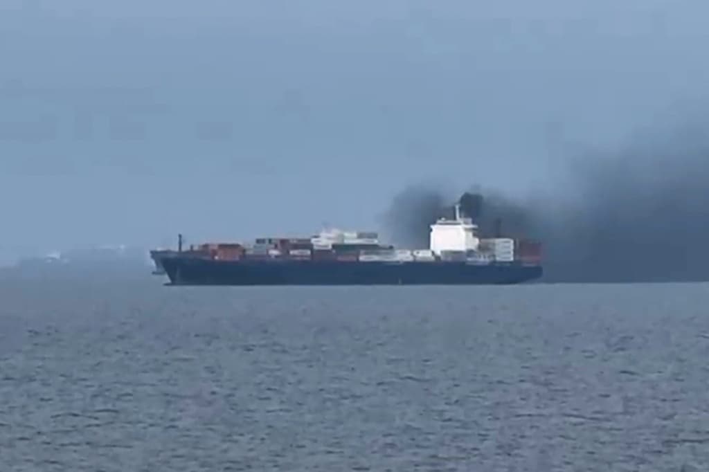 This image, taken from video footage shot by seafarer Wang Shang on Thursday, shows smoke billowing from a cargo vessel in the Gulf