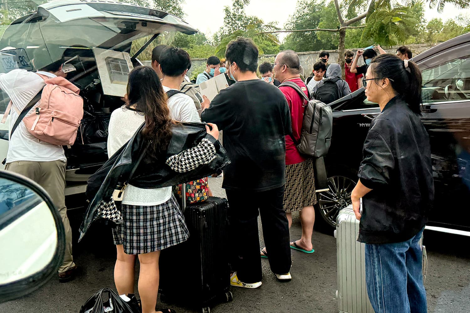 PhotoStory-เมื่อวันที่ 15 มกราคม 2026 คนงานกำลังขนสัมภาระขึ้นรถที่จอดรออยู่ หลังจากเดินออกมาจากบริเวณที่ต้องสงสัยว่าเป็นศูนย์กลางการฉ้อโกงในเมืองสีหนุวิลล์ Photo by TANG CHHIN SOTHY / AFP