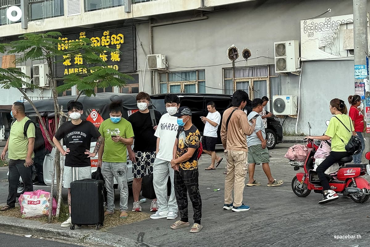 PhotoStory-คนงานยืนอยู่ริมถนนหลังจากเดินออกมาจากบริเวณที่ต้องสงสัยว่าเป็นศูนย์กลางการฉ้อโกง ใกล้กับคาสิโนแอมเบอร์ ในเมืองสีหนุวิลล์ เมื่อวันที่ 15 มกราคม 2026 Photo by TANG CHHIN SOTHY / AFP