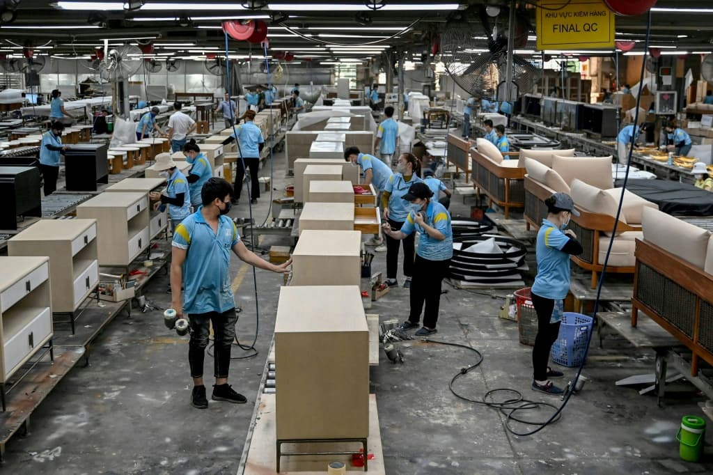 Workers assemble furniture inside the Jonathan Charles Fine Furniture factory in Ho Chi Minh City