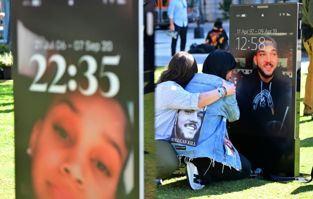 พ่อแม่และสมาชิกในครอบครัวที่สูญเสียลูกไป ชมภาพของลูกที่เสียชีวิต ซึ่งจัดแสดงอยู่ที่ "อนุสรณ์สถานแห่งหน้าจอที่สูญหาย" ในลอสแอนเจลิส งานศิลปะชิ้นนี้จัดแสดงภาพของเด็ก 50 คนที่เสียชีวิตจากอันตรายบนโลกออนไลน์