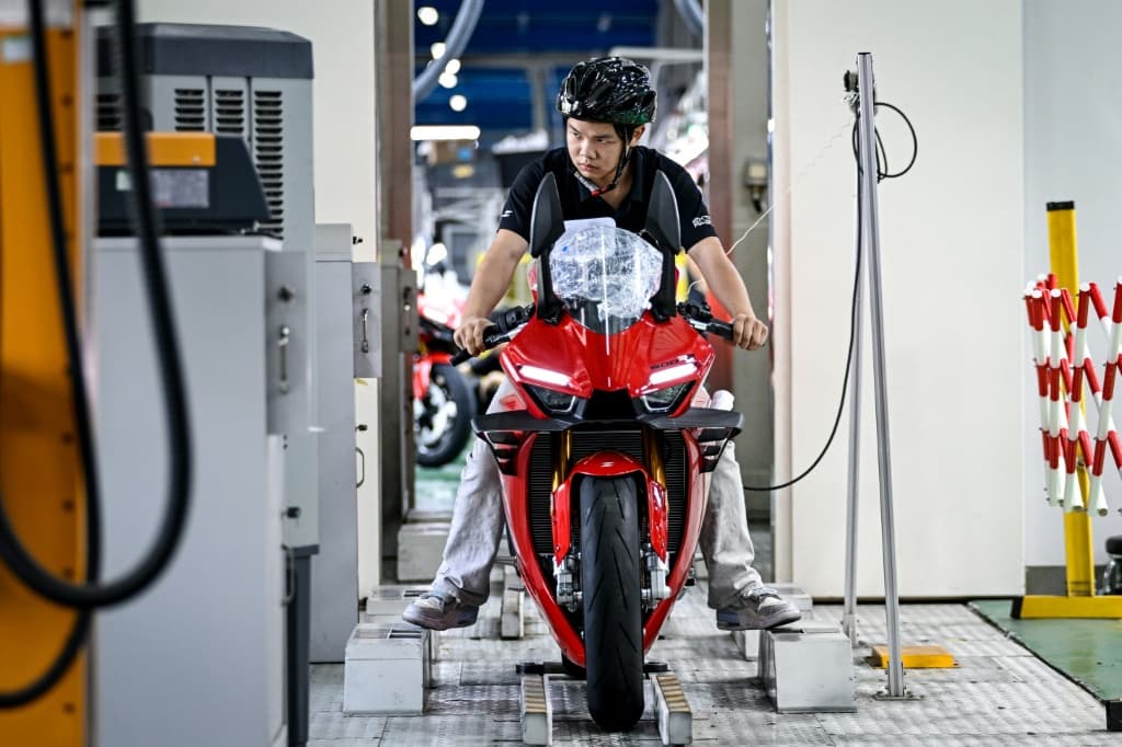 A worker tests a assembled motorcycle at the ZXMoto factory in Chongqing, southwestern China