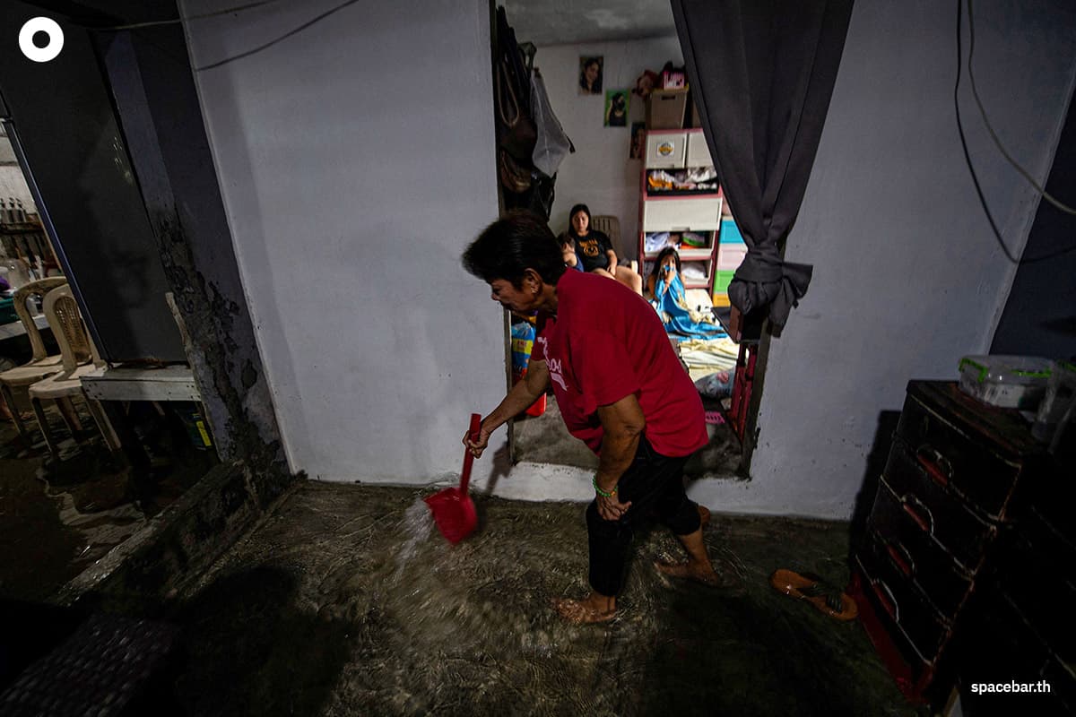 มาเรีย ทามาโย ใช้เวลาทุกเช้าตักน้ำจากบ้านที่ถูกน้ำท่วมของเธอบนเกาะปูกาด ทางตอนเหนือของมะนิลา / AFP