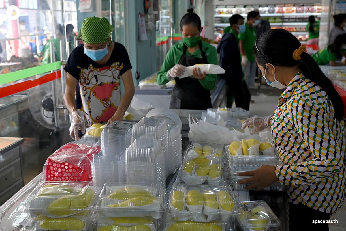 พนักงานกำลังเตรียมทุเรียนใส่กล่องที่ร้านค้าแห่งหนึ่งในกรุงพนมเปญ Photo by TANG CHHIN Sothy / AFP