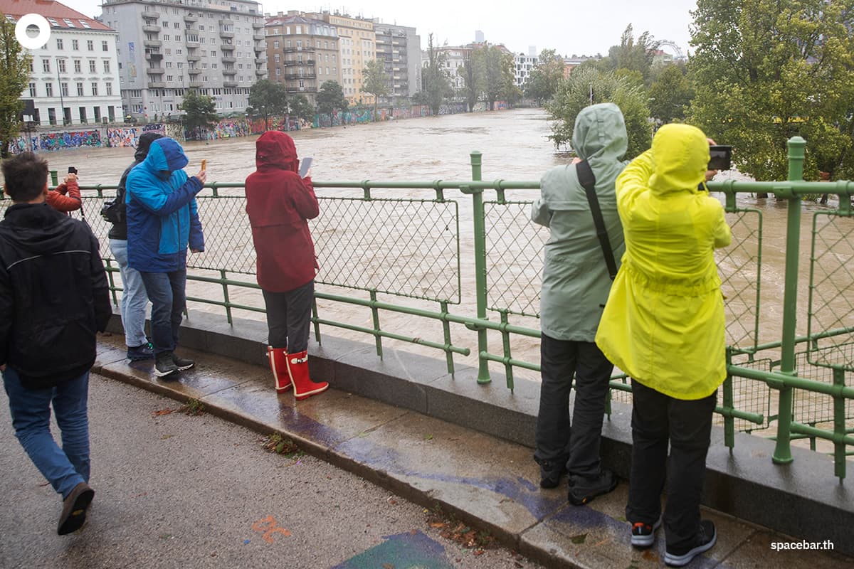 ผู้คนถ่ายภาพน้ำในคลองดานูบที่ล้นตลิ่งในกรุงเวียนนา ประเทศออสเตรีย เมื่อวันที่ 15 ก.ย. 2024 (Photo by Alex HALADA / AFP)