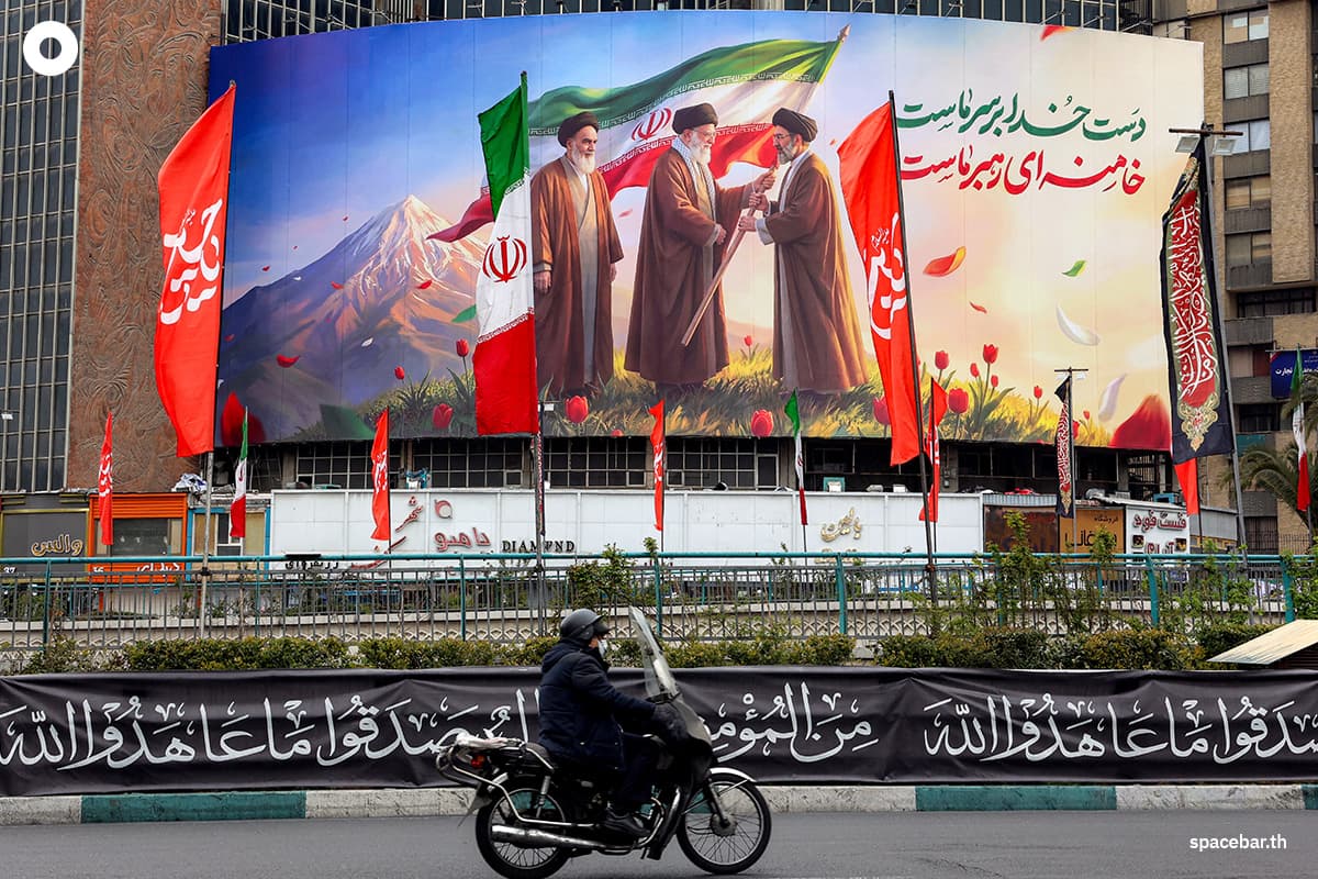 อิหร่านจัดพิธีแต่งตั้ง อยาตอลเลาะห์ มุจตาบา คาเมเนอี ให้ดำรงตำแหน่งผู้นำสูงสุดแทนบิดาด้วยการติดป้ายภาพของเขาทั่วประเทศ โดยในภาพเป็นป้ายผ้าที่จัดแสดงใจกลางกรุงเตหะราน เป็นภาพอยาตอลเลาะห์ รูฮอลลาห์ โคมัยนี (ซ้าย) อดีตผู้นำสูงสุดของอิหร่าน กำลังมองดูอยาตอลเลาะห์ อาลี คาเมเนอี (กลาง) ผู้สืบทอดตำแหน่ง มอบธงชาติให้กับมุจตาบา คาเมเนอี บุตรชายและผู้นำสูงสุดคนใหม่ Photo by - / AFP