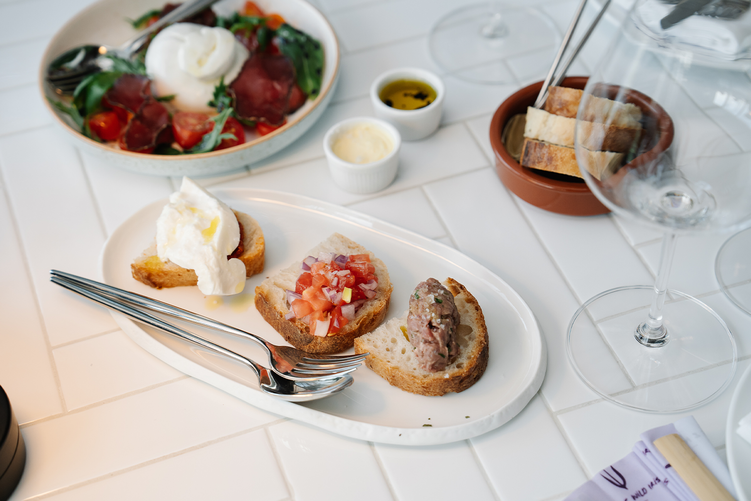 PhotoStory-Bruschetta trio, with beef tartare, classic tomato salsa and N_duja with burrata