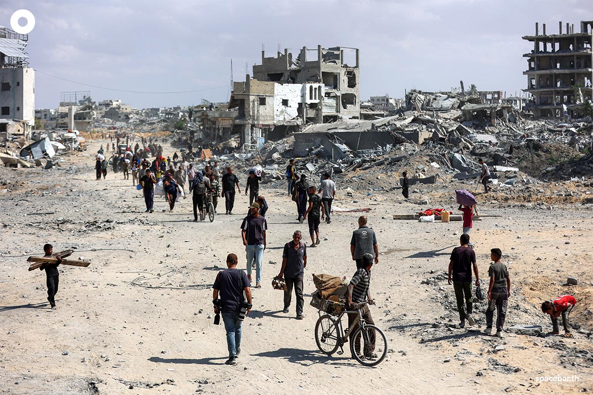 PhotoStory-   ชาวปาเลสไตน์เดินทางไปตามถนนผ่านซากปรักหักพังของอาคารที่ถูกทำลายในใจกลางเมืองข่าน ยูนิส ทางตอนใต้ของฉนวนกาซา มุ่งหน้าไปยังเมืองกาซา เมื่อวันที่ 10 ตุลาคม 2025 (OMAR AL-QATTAA / AFPPhoto by OMAR AL-QATTAA / AFP) 