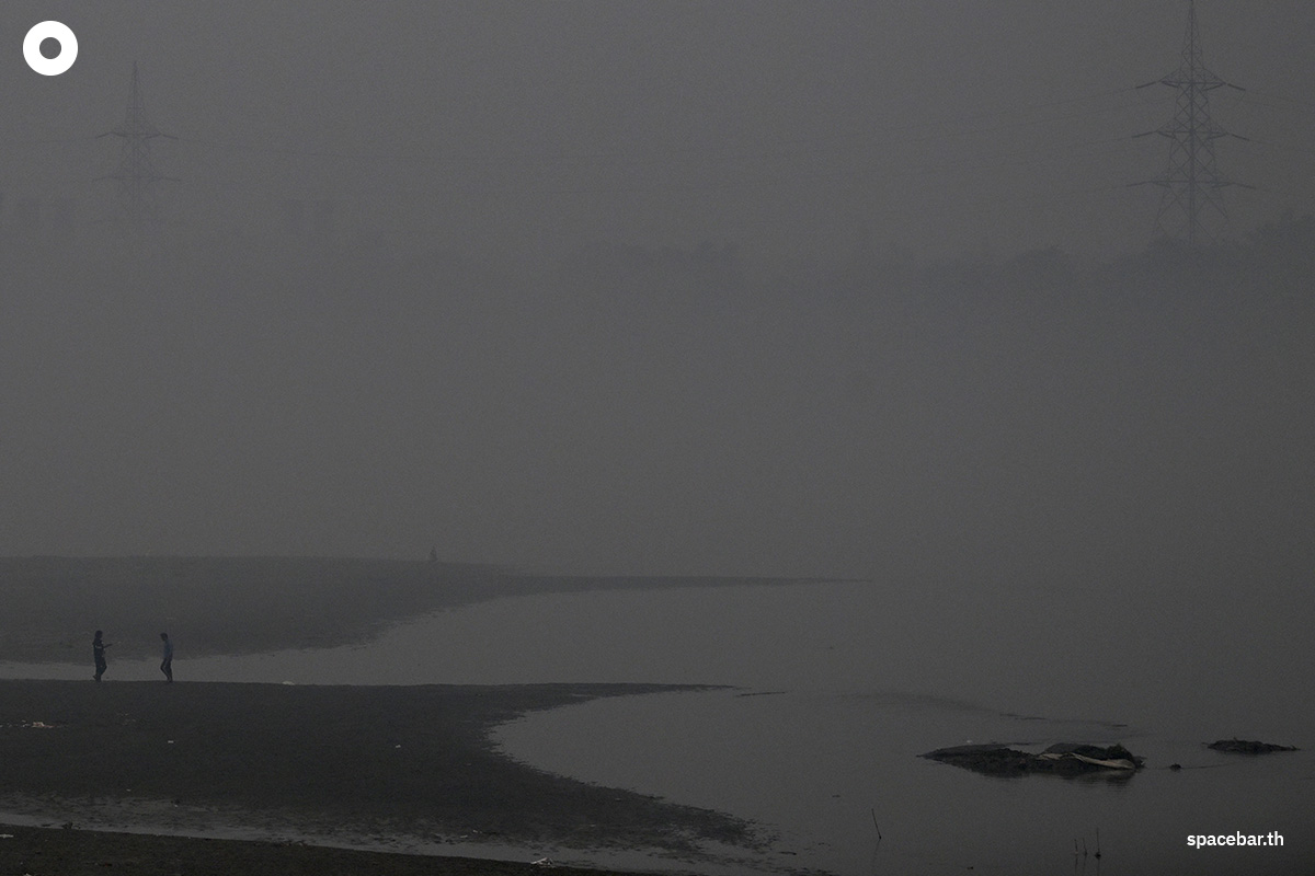 PhotoStory-   ชาย 2 คนเดินอยู่ริมแม่น้ำยมุนา ท่ามกลางหมอกควันหนาทึบในกรุงนิวเดลี เมื่อวันที่ 21 ตุลาคม 2025 (Photo by : ARUN SANKAR / AFP) 