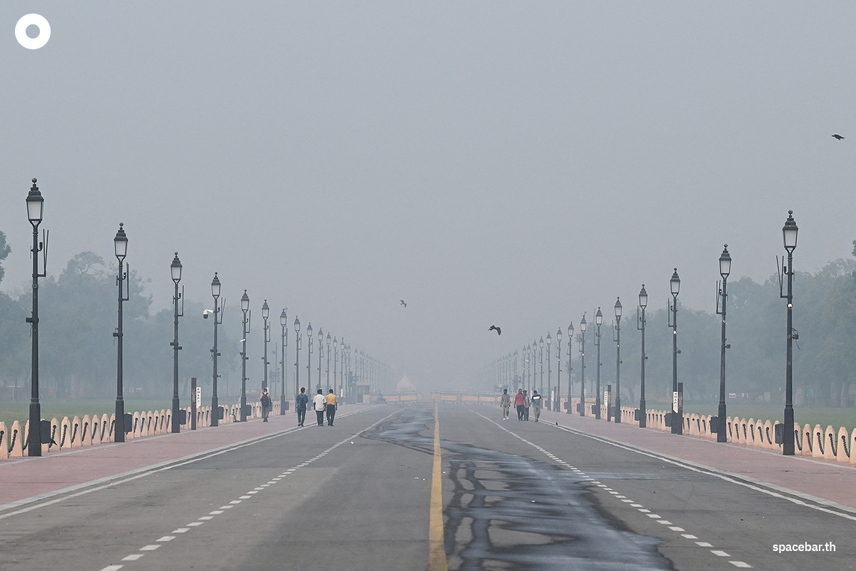 PhotoStory-   ผู้คนกำลังเดินไปตามถนน ‘Kartavya Path’ ใกล้ประตูอินเดีย ท่ามกลางหมอกควันหนาทึบที่ปกคลุมเส้นขอบฟ้ากรุงนิวเดลี เมื่อวันที่ 22 ตุลาคม 2025 (Photo by : SAJJAD HUSSAIN / AFP) 