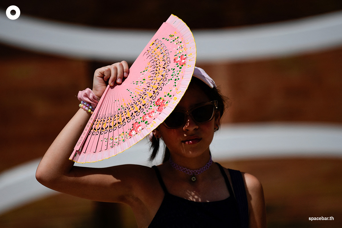 PhotoStory-หญิงรายหนึ่งใช้พัดบังแสงแดดท่ามกลางคลื่นความร้อนที่ส่งผลให้อุณหภูมิสูงถึง 46 องศาเซลเซียสในเมืองเซบียา Photo by CRISTINA QUICLER / AFP