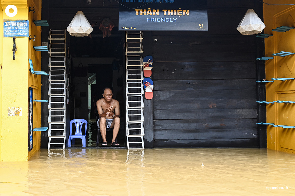 PhotoStory-   ชายคนหนึ่งนั่งอยู่บริเวณทางเข้าร้านค้าของเขาที่ถูกน้ำท่วม หลังฝนตกหนักในเมืองฮอยอัน เมื่อวันที่ 30 ตุลาคม 2025 (Photo by NHAC NGUYEN / AFP) 